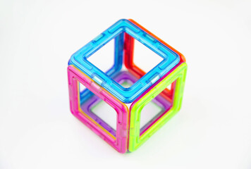 A cube made of colorful transparent magnet squares (puzzle builder for kids), closeup isolated on a...