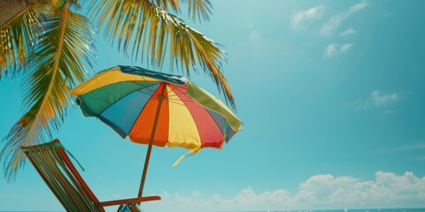 A colorful umbrella is sitting on a beach chair, providing shade from the sun. The scene is bright and cheerful, with a clear blue sky and palm trees in the background