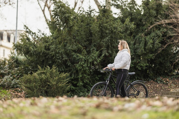 Woman Walking Next to Bike in Park