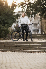 Woman Standing Next to Bike on Steps In City Park