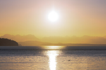 Golden Sunrise above the horizon with mountains and ocean - 779987343