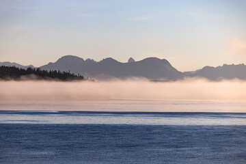 Misty lake framed by mountains, creating a serene natural landscape - 779988118
