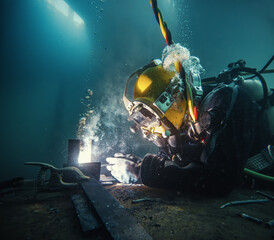 Commercial diver welding and cutting underwater - 779988329