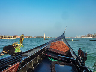 Sitting in a gondola driving through the channels in Venice, Venetian Lagoon, Veneto, Northern Italy, Europe. Romantic boat ride watching landmarks. Summer vacation in city of love. Tourism
