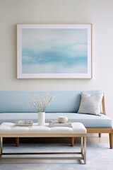 Blue and white coastal living room with sofa, artwork, flowers in vase, coffee table and books.