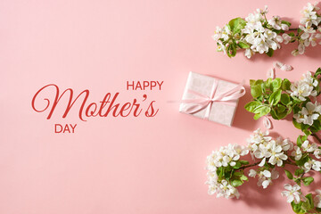 Flat lay happy mothers day frame with spring flowers and  gift box on a pink background