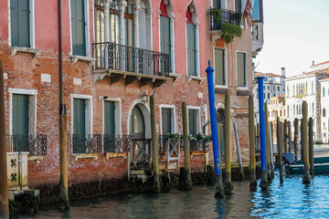 Fototapeta na wymiar Floating boats with panoramic view of a water channel in city of Venice, Veneto, Italy, Europe. Venetian architectural landmarks and old houses facades along water canal. Urban tourism in summer