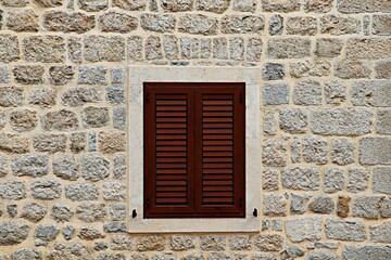 Window of a residential building with closed wooden shutters