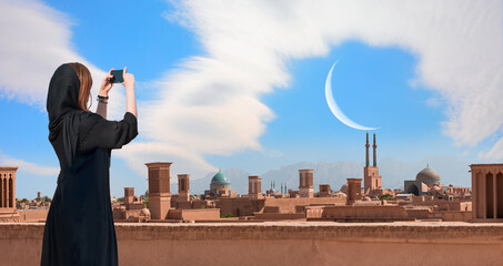 Beautiful Iranian girl wearing abaya with taking selfie - Historic City of Yazd with famous wind towers - YAZD, IRAN