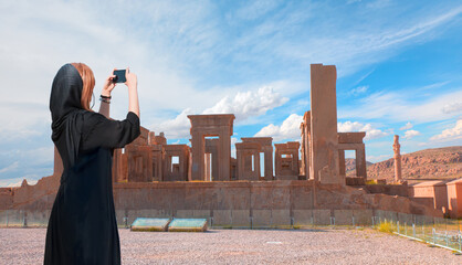 Happy Iranian girl wearing abaya taking selfie - Ruins of the ancient Persian capital city of Persepolis, Iran