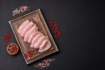 Slices of raw chicken or turkey fillet with salt, spices and herbs