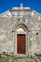 Fototapeta na wymiar Wooden door to a stone, historic Orthodox chapel on the island of Crete