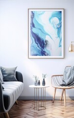 Blue and white abstract painting in a golden frame hanging on a white wall above a white side table with two green vases on it, next to a gray couch and a wooden chair in a modern living room.