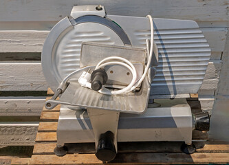 Electric meat slicer machine outdoors on a market stall