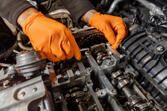 Mechanic's Hands Repairing Car Engine in Auto Service