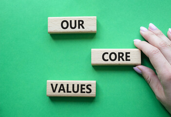 Our core values symbol. Concept words Our core values on wooden blocks. Beautiful green background....