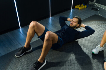 Man performing sit-ups at fitness class
