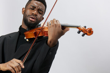 Professional violinist performing classical music on the violin in a stylish suit on white...