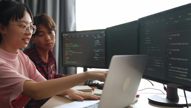 Slow motion back end software developer engineer for computer programming working together on debugging writing computing code, solving complex algorithms display on monitor in office. Burgeoning