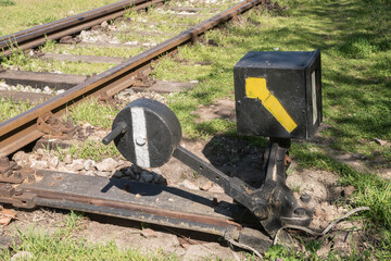 Hand-operated vintage railroad switch with lever, weight and signal closeup