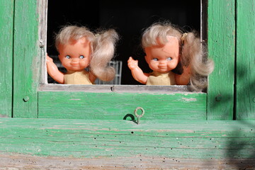 Spooky twin sister dolls looking through the window