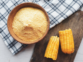 cornmeal in bowl andwooden background