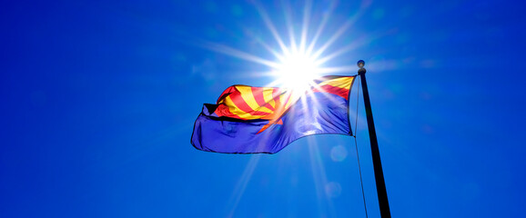 Arizona State Flag Flying on Flagpole with Sunshine Sunstar in Sky