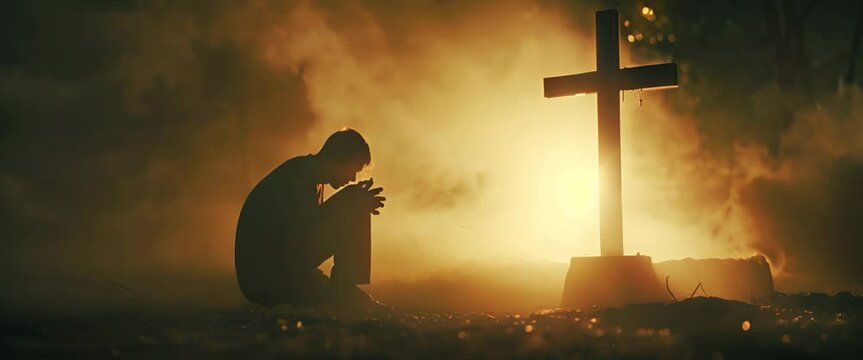 Christian man praying in front of the cross
