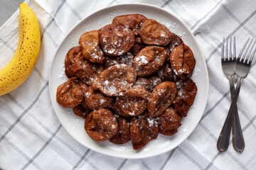 Homemade Banana Fritters with Powdered Sugar on a Plate, top view.