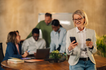 Senior businesswoman contacting clients on a phone during meeting.