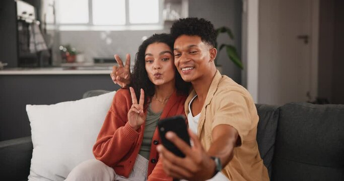 Happy couple, hug and peace sign with selfie on sofa for bonding, photography or moment together at home. Young man and woman with smile, love or emoji for capture, photo or picture at the house
