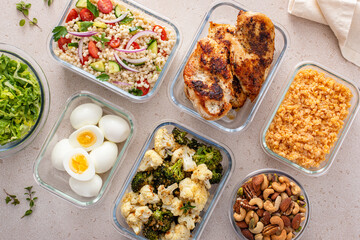 Healthy meal prep with cooked chicken breast, boiled eggs, roasted vegetables, cooked lentils,...