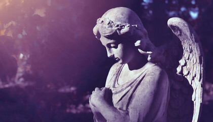 Gothic sad angel statue in cemetery, monochrome image, selective focus	