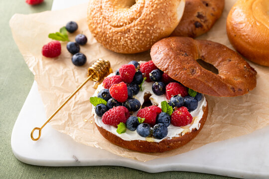 Cinnamon bagel with cream cheese, fresh berries and honey