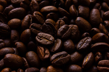 Roasted coffee beans close up background. Textured background of fresh roasted coffee beans.