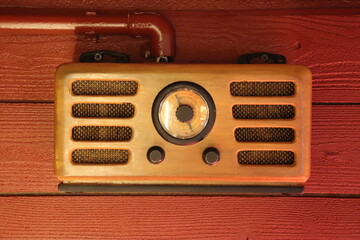 An antique retro radio hangs on the wall. Radio waves, radio receiver, rarity.