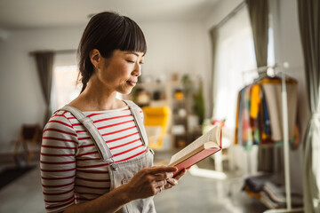 one female mature japanese woman read book at home