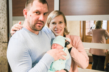 A Mother and father with her newborn baby at the home