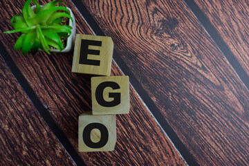 Concept of The wooden Cubes with the word EGO on wooden background.