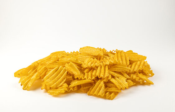 A mountain of wavy chips on a white background. The concept of obesity.