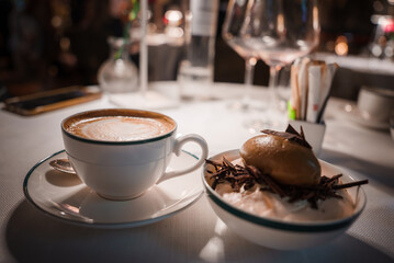 Close up view of elegant table setting in a high end restaurant. White cup of cappuccino and...