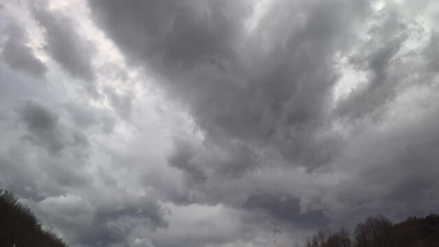 sunset clouds before a thunderstorm quickly sweep by in accelerated time lapse filming, lush picturesque colorful sky over the mountains