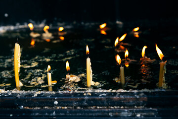 Flickering flames of old candles In the ancient church. Sacred space with reverence and tranquility