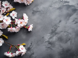 Obraz na płótnie Canvas Sakura tree blossoms elegantly arranged on a gray stone surface, offering text space