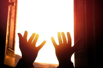 Hands raised in prayer towards the light, spiritual concept, stock photo