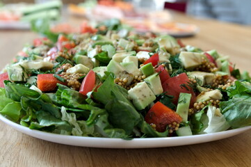green salad with avocado, tomatos and feta cheese with french mustard