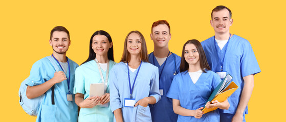Group of medical students on yellow background