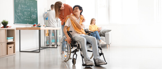 Teenage girl with her classmate in wheelchair at school