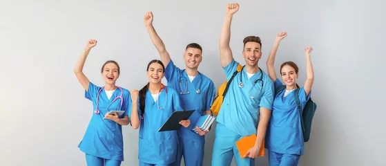 Poster Group of happy medical students on light background © Pixel-Shot
