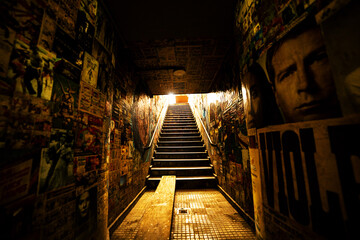 Escadaria de galeria subterrânea com paredes cheia de grafite na cidade  de São Paulo.  